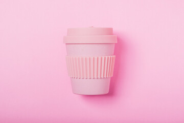Reusable eco friendly bamboo cup for take away coffee on pink background. Flat lay, top view. Bring...