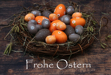  Nest mit Ostereiern in den Farben braun und orange mit Ostergrüßen.