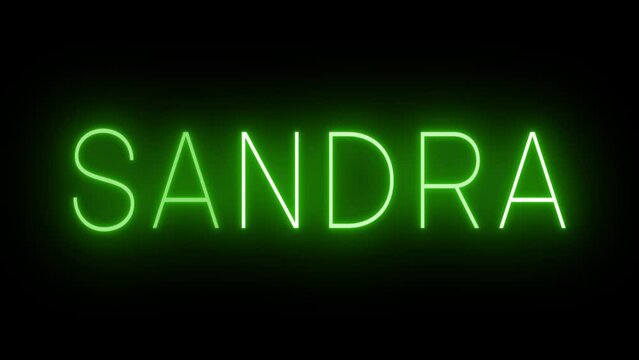 Flickering green retro style neon sign glowing against a black background