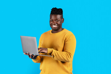 Happy Young Black Man With Laptop In Hands Posing Over Blue Background