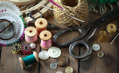 Colored threads and items for sewing, on an old background.