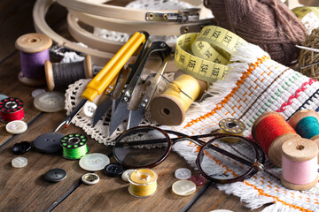 Colored threads and items for sewing, on an old background.