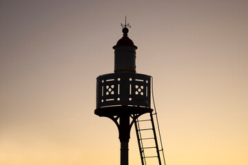 Vintage lighthouse silhouette during sunset