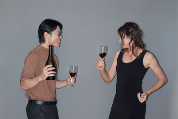 Cheerful party guests drinking wine and dancing