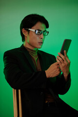 Shocked Asian man reading text message on smartphone