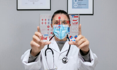 Female doctor looking at transparent tablet with medical digital diagnostic on screen. Futuristic health care head up display concept.