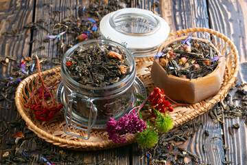 Sweet, hot tea with dry tea leaves, on an old background.