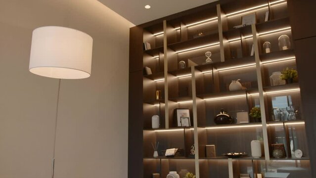 Luxurious interior of room with bookcase. Stock footage. Beautiful stylish furniture design in modern apartments. Luminous details of luxurious modern interior