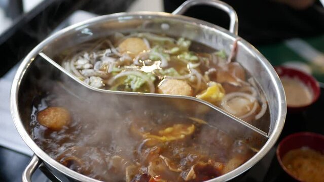 Chinese spicy hot pot cuisine while cooking meatball, fishball and wanton in hot boil chinese style soupbase
