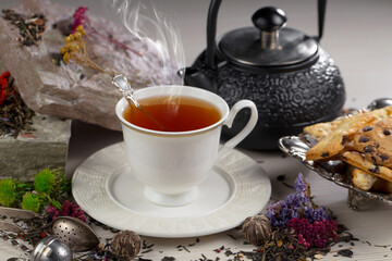 Sweet, hot tea with dry tea leaves, on an old background.