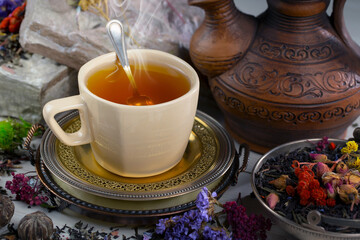 Dry tea leaves in a spoon on an old background
