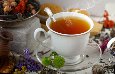 Sweet, hot tea with dry tea leaves, on an old background.