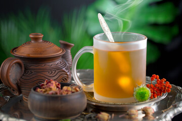 Sweet, hot tea with dry tea leaves, on an old background.