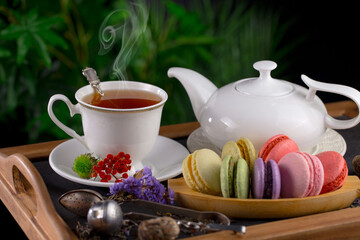 Sweet, hot tea with dry tea leaves, on an old background.