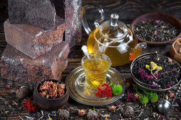 Sweet, hot tea with dry tea leaves, on an old background.