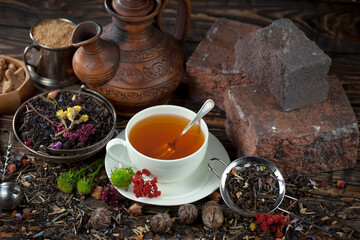 Sweet, hot tea with dry tea leaves, on an old background.