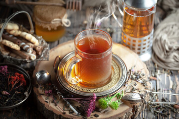 Dry tea leaves in a spoon on an old background