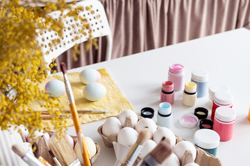 table with easter colored eggs and paints