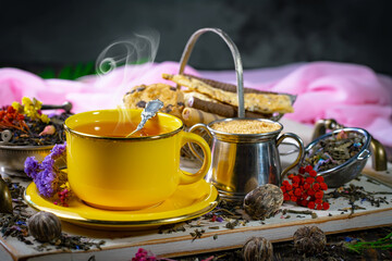 Sweet, hot tea with dry tea leaves, on an old background.