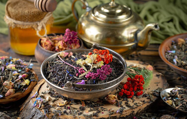 Dried tea leaves in a spoon, on an old background.