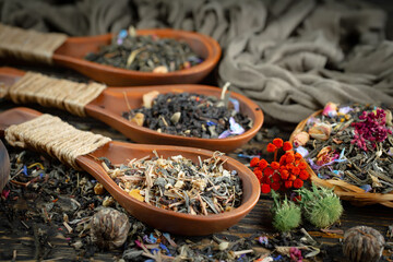 Dried tea leaves in a spoon, on an old background.