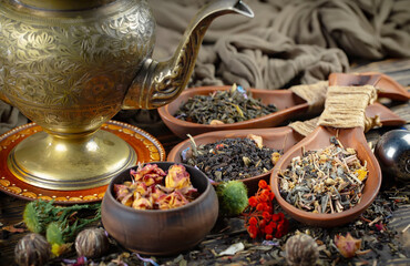 Dried tea leaves in a spoon, on an old background.