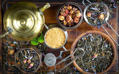 Fototapeta na wymiar Dried tea leaves in a spoon, on an old background.