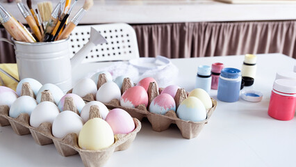 table with easter colored eggs and paints