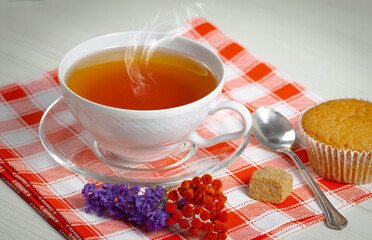 Sweet, hot tea with dry tea leaves, on an old background.