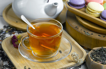 Sweet, hot tea with dry tea leaves, on an old background.