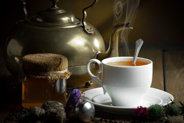 Sweet, hot tea with dry tea leaves, on an old background.