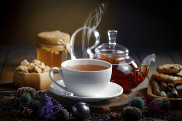 Sweet, hot tea with dry tea leaves, on an old background.