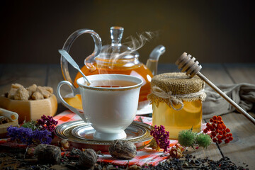 Sweet, hot tea with dry tea leaves, on an old background.