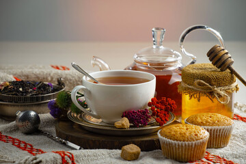 Sweet, hot tea with dry tea leaves, on an old background.