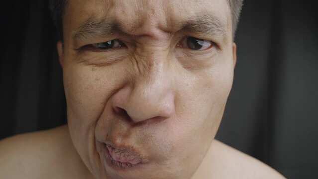 Close up of unhappy man squeezing nose with fingers, smells something awful, Man feeling bad about bad smell.