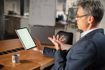 Portrait of businessman in office. Man using digital tablet. Businessman having video call..