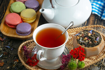 Sweet, hot tea with dry tea leaves, on an old background.