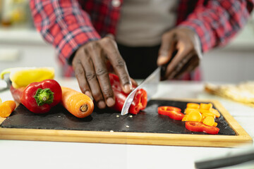 Close up of man cutting vegetables. Handsome chef preparing food..