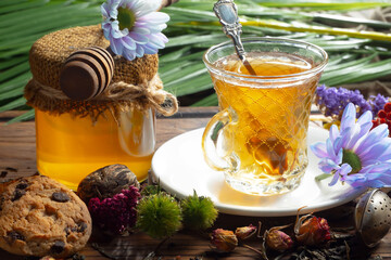 Sweet, hot tea with dry tea leaves, on an old background.