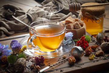 Sweet, hot tea with dry tea leaves, on an old background.