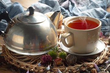 Sweet, hot tea with dry tea leaves, on an old background.