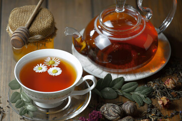 Obraz na płótnie Canvas Sweet, hot tea with dry tea leaves, on an old background.