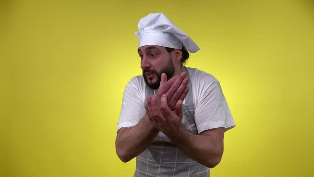 Expressive male cook gesturing, scolding, looking at camera isolated on yellow background. Passionate bearded middle-aged man chef talking emotionally, blaming sb. Cooking chief, bossy person.