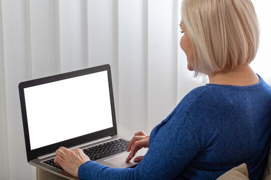 Business woman in profile working using a laptop. Gadget screen white mockup template for your image.