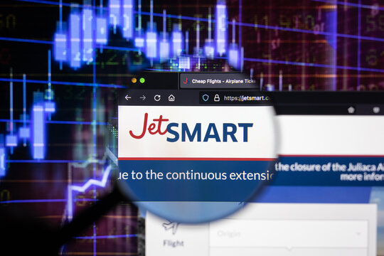 Jetsmart company logo on a website with blurry stock market developments in the background, seen on a computer screen through a magnifying glass	