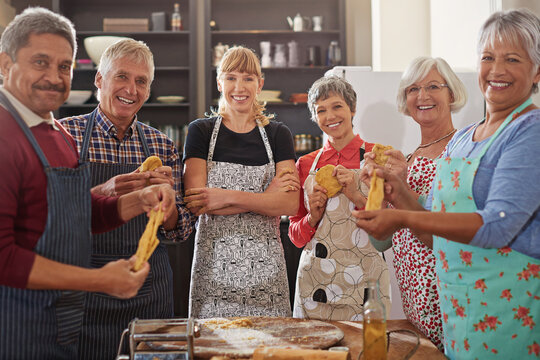 An apron is just a cape on backwards. a group of people applauding after their cooking class.
