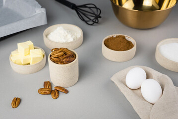 Close-up of the ingredients for brownie on a grey surface in the modern kitchen. Culinary blog.