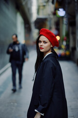 Fashion woman portrait walking tourist in stylish clothes with red lips walking down narrow city street, travel, cinematic color, retro vintage style, dramatic.