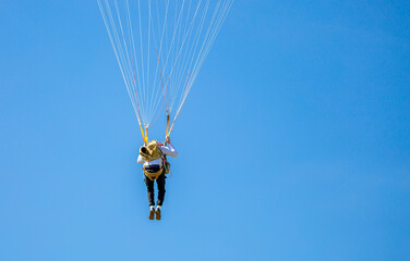 Skydiving. Flying parachutists against the background of the blue sky and mountains. Extreme sport and entertainment.
