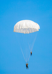Skydiving. Flying parachutists against the background of the blue sky and mountains. Extreme sport...